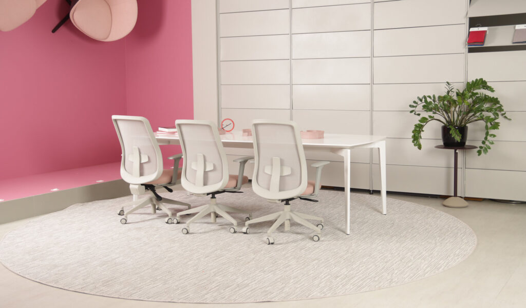 Sala de reunião com parede colorida e cadeiras brancas