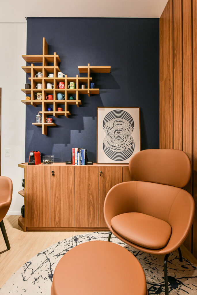 Espaço colaborativo com poltronas e estante decorativa